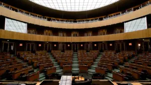 Tuščia parlamento posėdžių salė, primenanti Lietuvos Seimo svarstymus dėl 2027 metų biudžeto.