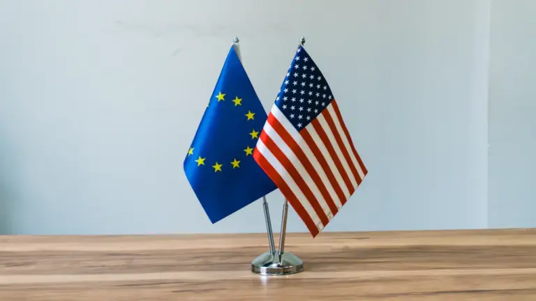 Europos Sąjungos ir Jungtinių Amerikos Valstijų vėliavos pastatytos ant stalo diplomatiniam susitikimui.