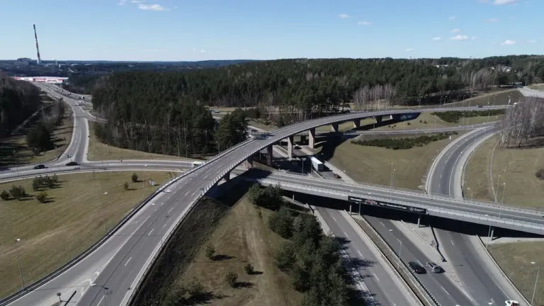 Daugiapakopė transporto mazgo sankryža Vilniuje, vaizdas iš viršaus, eismo srautas dienos metu.