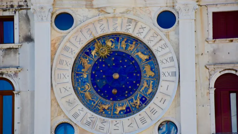 Didelis detalus astrologinis laikrodis ant istorinio pastato sienos Europos mieste