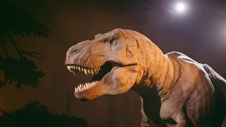 Didelio dinozauro maketas su atvira burna kino teatro renginio anonsui.
