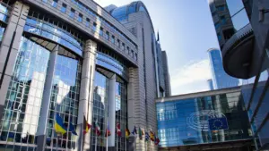 Modernaus Europos Parlamento pastato fasadas su plevėsuojančiomis vėliavomis Briuselyje.