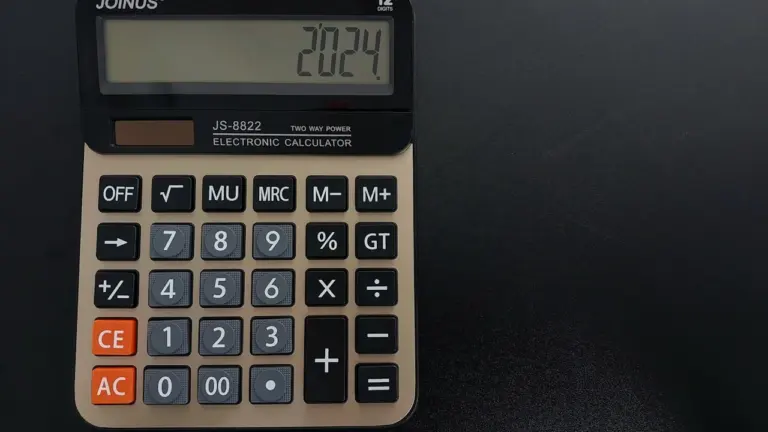 Elektroninis skaičiuotuvas ant stalo, naudojamas kelionės degalų sąnaudoms ir biudžetui tiksliai suskaičiuoti.
