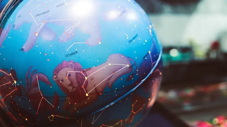Mėlynas Zodiako ženklų gaublys su Liūto žvaigždyno atvaizdu tamsiame fone.